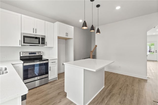 kitchen featuring stainless steel appliances, light wood-type flooring, white cabinets, and light countertops