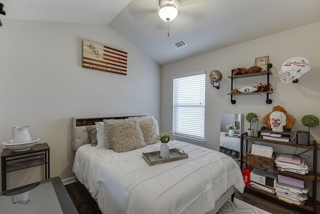 bedroom featuring ceiling fan, visible vents, vaulted ceiling, and wood finished floors