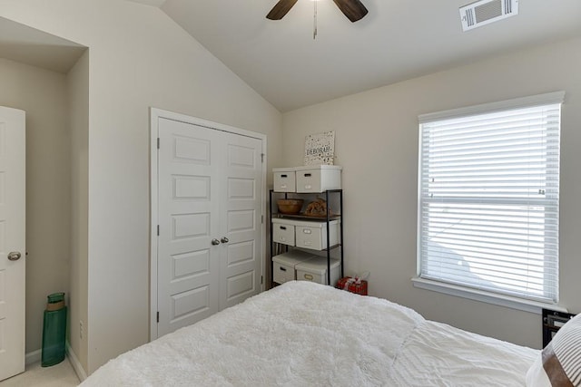 bedroom featuring vaulted ceiling, multiple windows, a closet, and visible vents