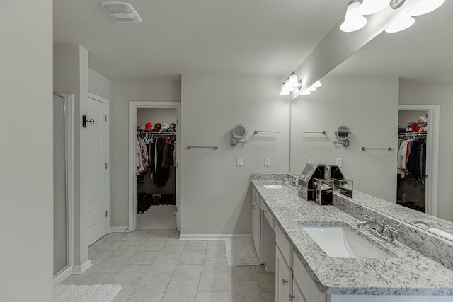 bathroom featuring double vanity, a stall shower, visible vents, and a sink