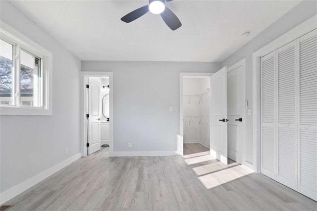 unfurnished bedroom with ensuite bathroom, ceiling fan, and light hardwood / wood-style flooring