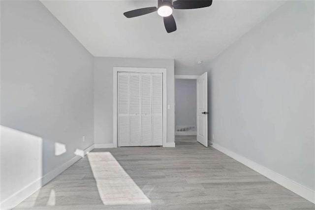 unfurnished bedroom with ceiling fan, light hardwood / wood-style floors, and a closet