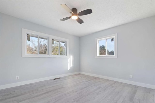 spare room featuring ceiling fan, a textured ceiling, and light wood-type flooring