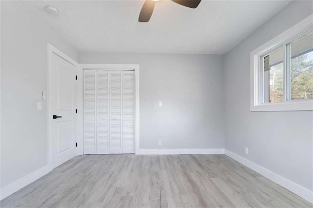 unfurnished bedroom featuring a closet, ceiling fan, and light wood-type flooring