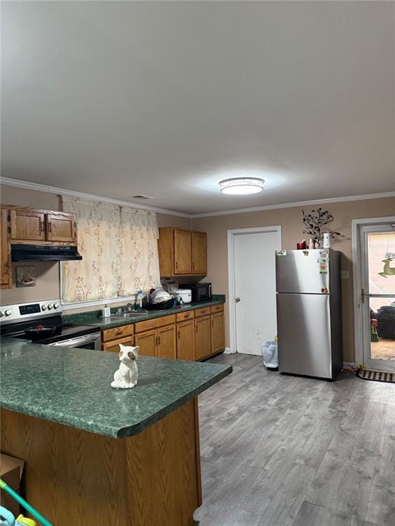 kitchen featuring kitchen peninsula, hardwood / wood-style floors, stainless steel appliances, and ornamental molding