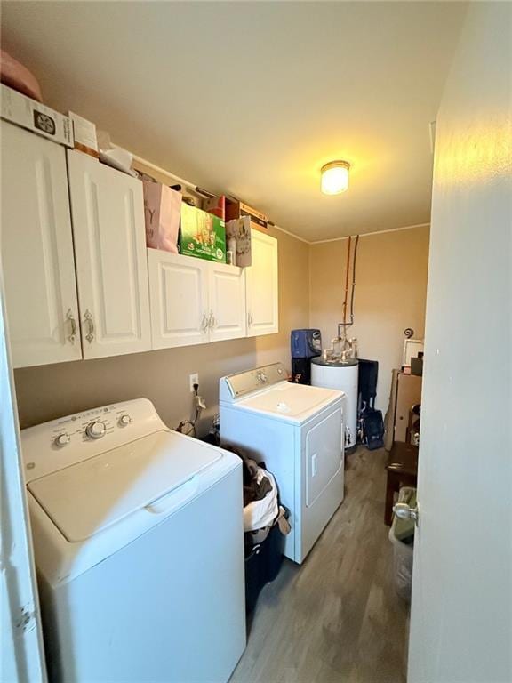 laundry area with cabinets, wood-type flooring, separate washer and dryer, and electric water heater