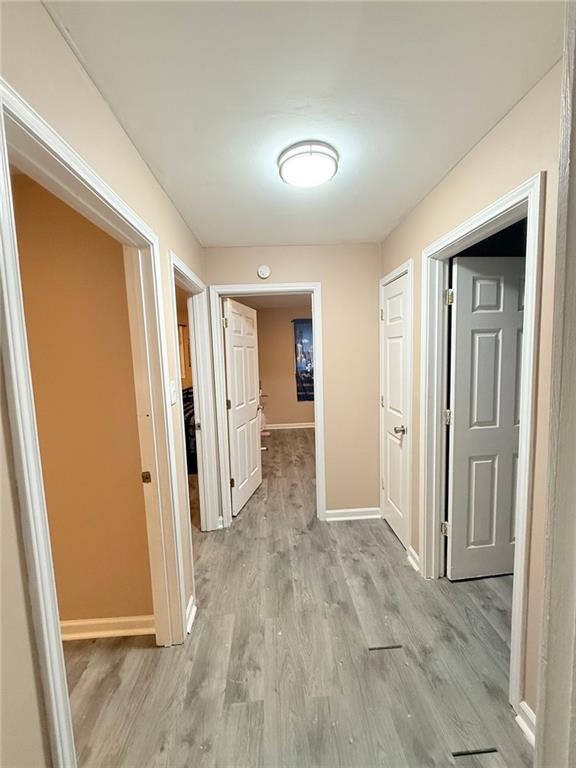 corridor with light hardwood / wood-style floors