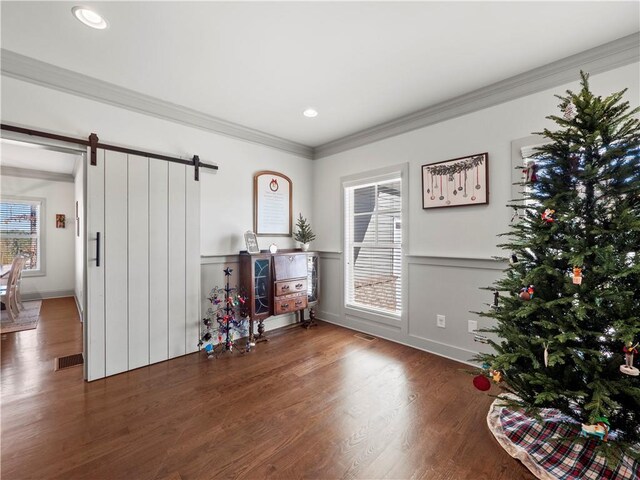 miscellaneous room featuring a barn door, dark hardwood / wood-style floors, and ornamental molding