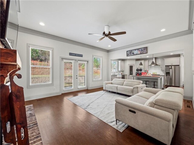 living room with ceiling fan, dark hardwood / wood-style flooring, french doors, and ornamental molding