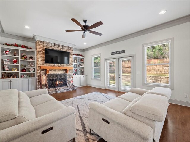 living room featuring dark hardwood / wood-style floors, a fireplace, crown molding, and ceiling fan