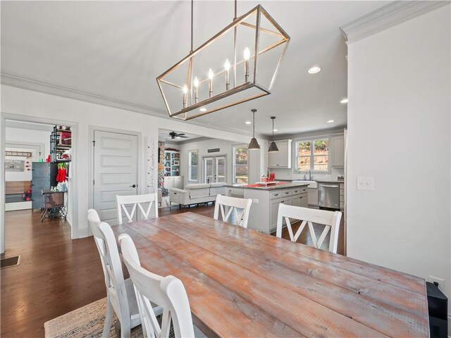 dining area featuring crown molding, dark hardwood / wood-style floors, and ceiling fan with notable chandelier