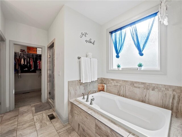 bathroom featuring independent shower and bath