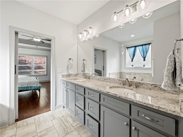 bathroom with hardwood / wood-style floors, ceiling fan, and vanity