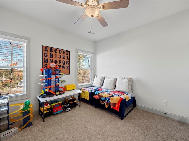 bedroom featuring multiple windows, ceiling fan, and carpet floors