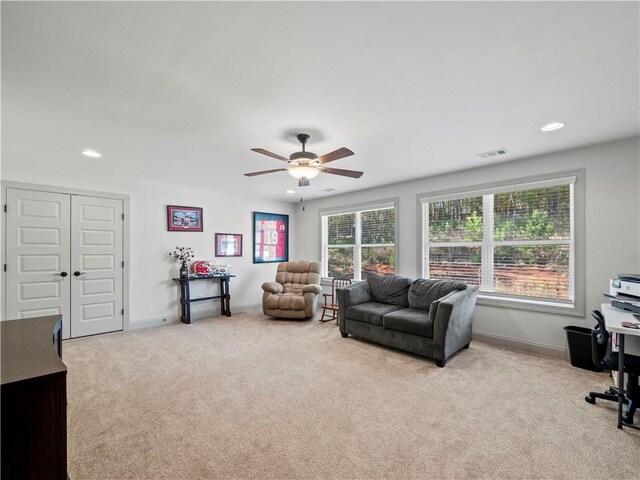 carpeted living room with ceiling fan and a healthy amount of sunlight