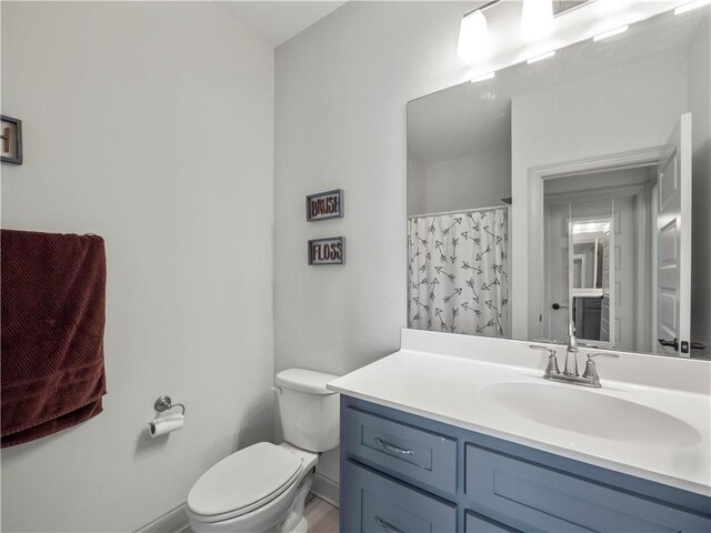 bathroom with vanity, toilet, and walk in shower