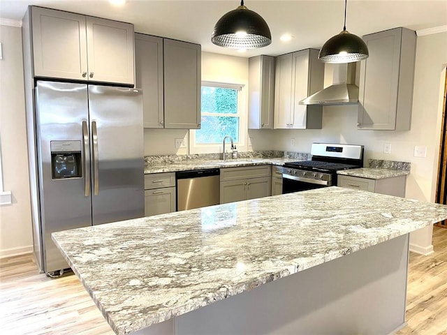 kitchen featuring wall chimney exhaust hood, light stone counters, stainless steel appliances, and gray cabinetry