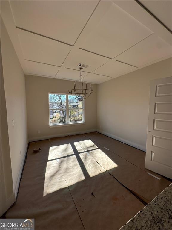 unfurnished dining area with a notable chandelier