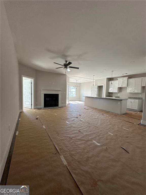 unfurnished living room featuring ceiling fan