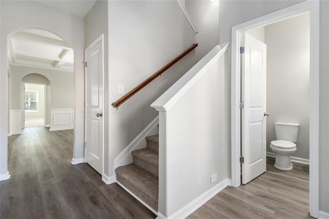 stairway with hardwood / wood-style floors, beamed ceiling, and coffered ceiling