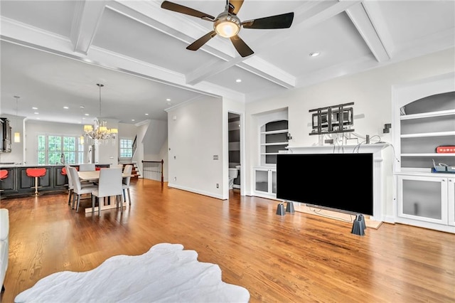 living room with ceiling fan with notable chandelier, beam ceiling, and light wood-type flooring