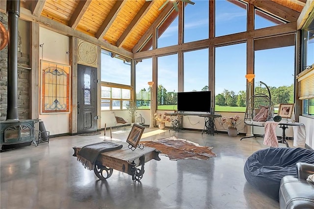 sunroom / solarium with a wood stove, lofted ceiling with beams, and wood ceiling