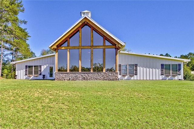 rear view of property featuring a yard and a sunroom