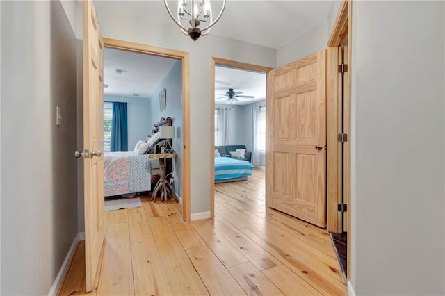 hall featuring a notable chandelier and light wood-type flooring