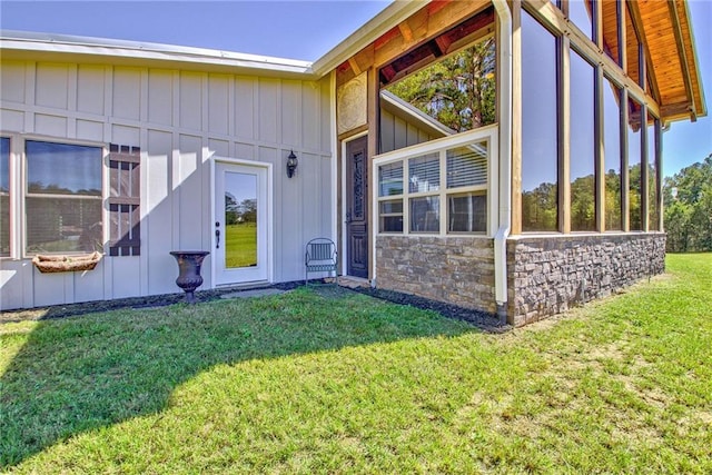 view of home's exterior with a yard and a sunroom