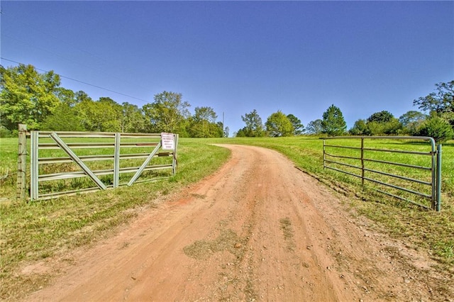 view of gate featuring a yard and a rural view