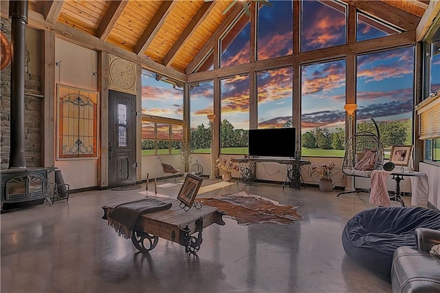 sunroom / solarium with wood ceiling, lofted ceiling with beams, and a wood stove