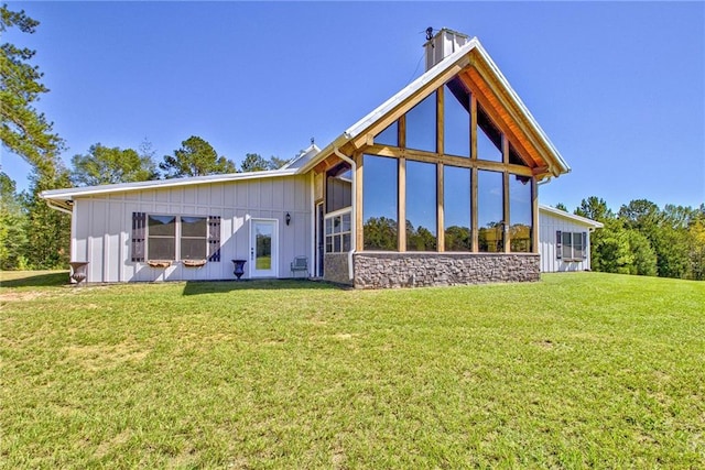 back of property featuring a sunroom and a lawn