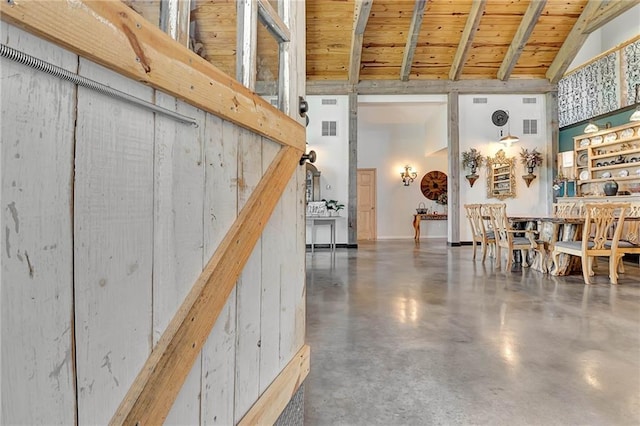 interior space with a barn door and wooden ceiling