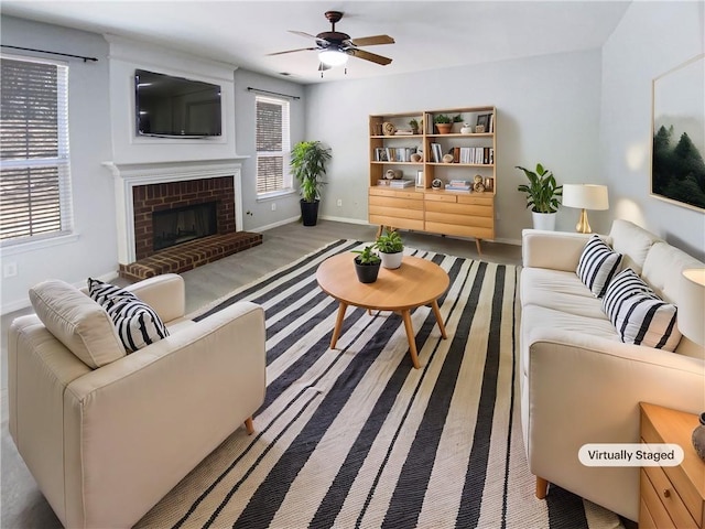 living room with baseboards, a brick fireplace, and a ceiling fan