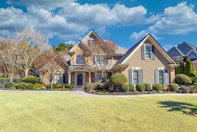 view of front of house featuring stone siding, a front yard, and stucco siding