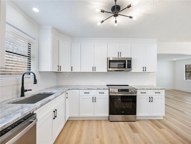 kitchen featuring sink, light hardwood / wood-style flooring, stainless steel appliances, and white cabinets