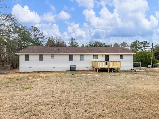 rear view of property featuring central AC unit, a yard, and a deck