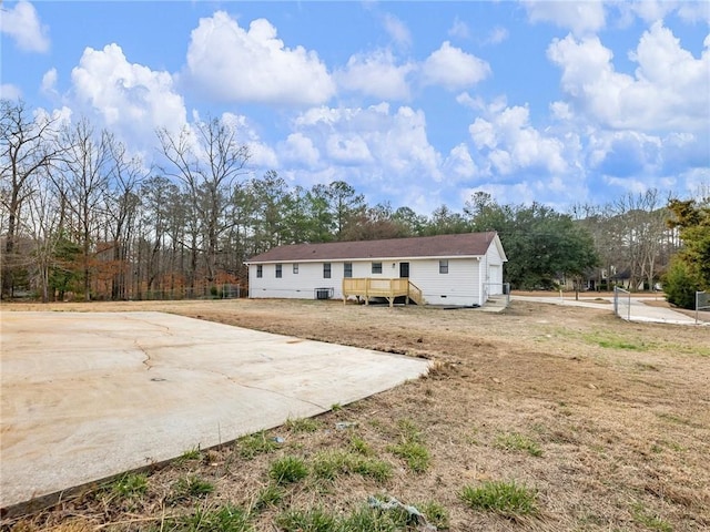 view of front of home with central AC unit, a front lawn, and a deck