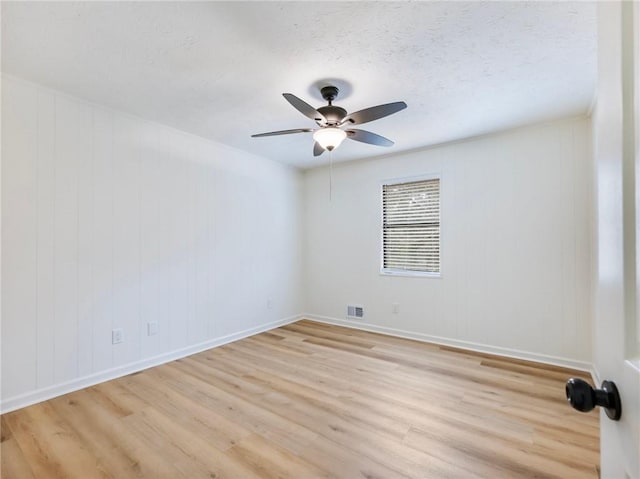 empty room with ceiling fan, a textured ceiling, and light hardwood / wood-style floors