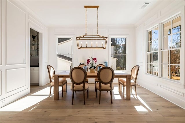 dining area featuring hardwood / wood-style flooring, ornamental molding, and a chandelier