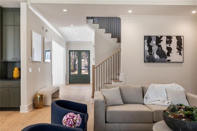 living room featuring ornamental molding, french doors, and light wood-type flooring