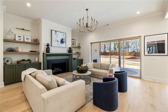 living room with crown molding, light hardwood / wood-style floors, and a chandelier