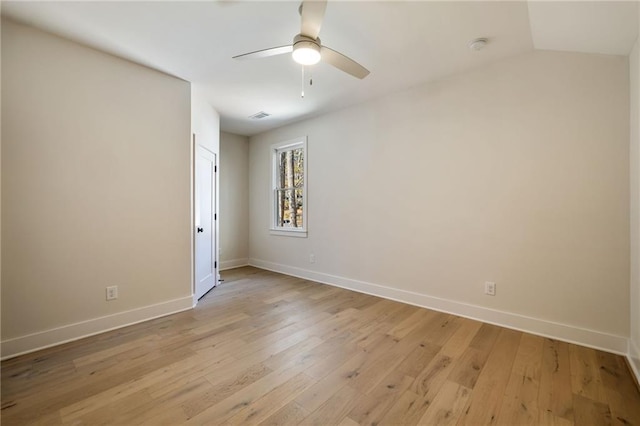 empty room with vaulted ceiling, ceiling fan, and light wood-type flooring