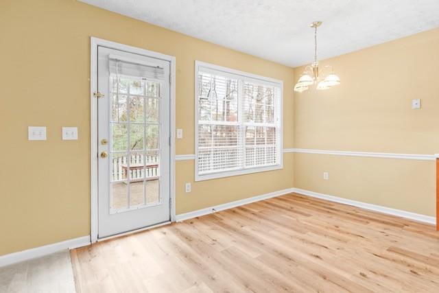 doorway to outside featuring a chandelier and hardwood / wood-style flooring