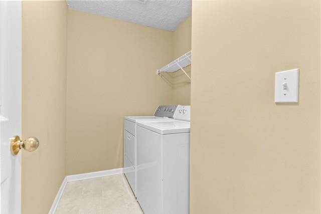 washroom featuring independent washer and dryer and a textured ceiling