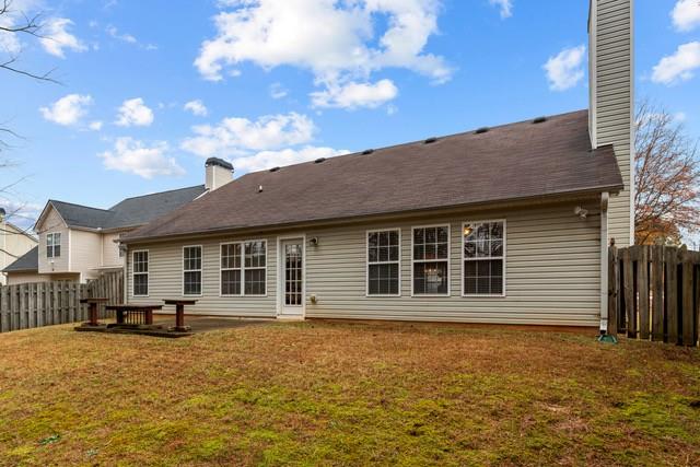 rear view of house featuring a yard