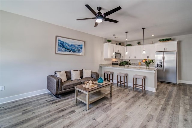 living room featuring ceiling fan and light wood-type flooring