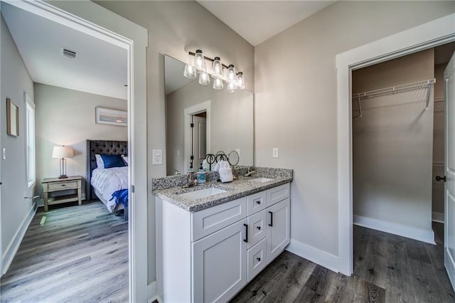 bathroom featuring dual bowl vanity and hardwood / wood-style floors