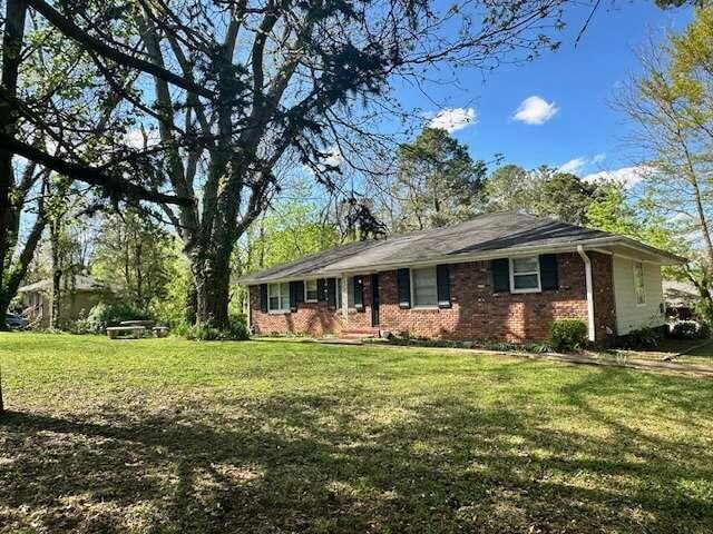 ranch-style home featuring a front lawn