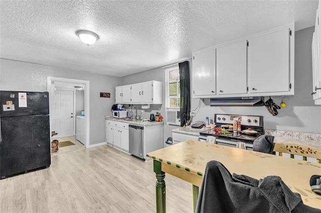 kitchen featuring appliances with stainless steel finishes, light wood-style flooring, light countertops, white cabinetry, and washer and dryer